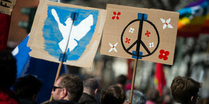 Schilder mit Friedenssymbolen bei einer Demonstration in Berlin