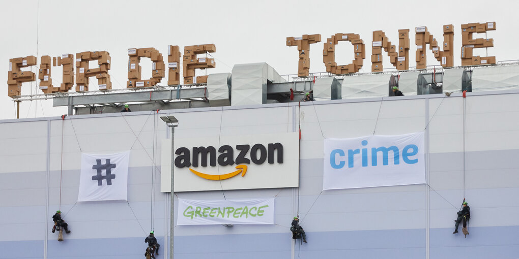 Greenpeace-Aktivisten seilen sich am Gebäude der Amazon Logistik Winsen GmbH ab.