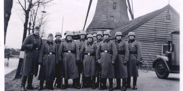 Deutsche Unifpormierte stehen vor einer Windmühle