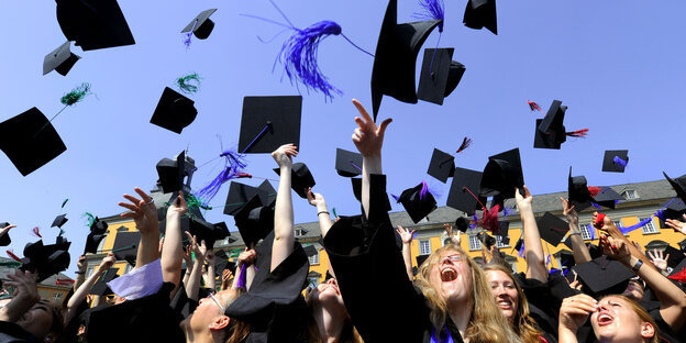Studierende werfen ihre Hüte in die Luft
