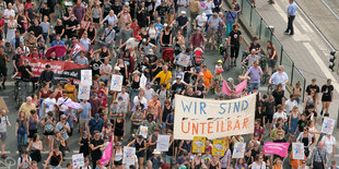 Demonstrantinnen und Demonstranten bei einer Unteilbar-Demonstration. Sie halten bunte Transparente in die Höhe.