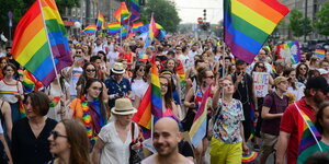 auf einer Demonstration tragen viele Menschen Regenbogenfarben