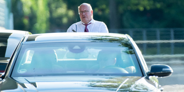 Wirtschaftsminister Peter Altmaier steht hinter seinem Dienstwagen