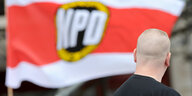 Ein Nazi vor einer Flagge der NPD