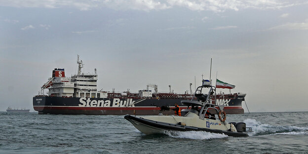 Ein Motorboot vor einem Öltanker