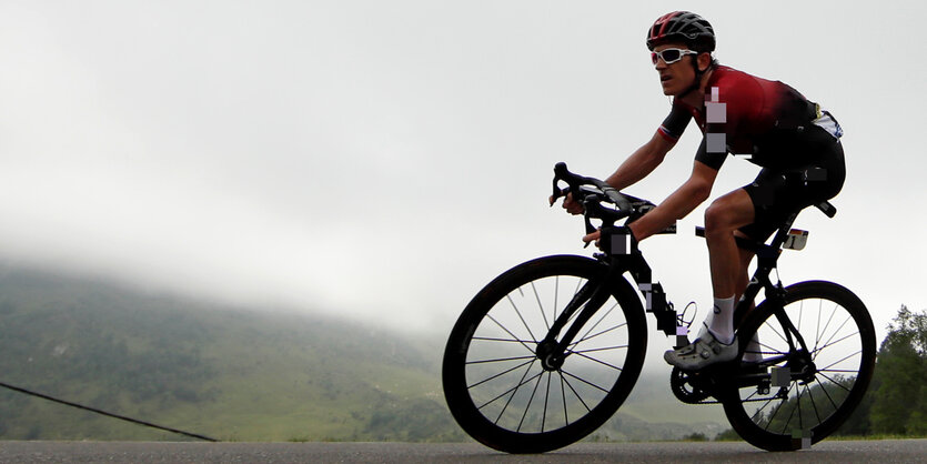 Radrennfahrer. Im Hintergrund ein Abgrund und Wolken