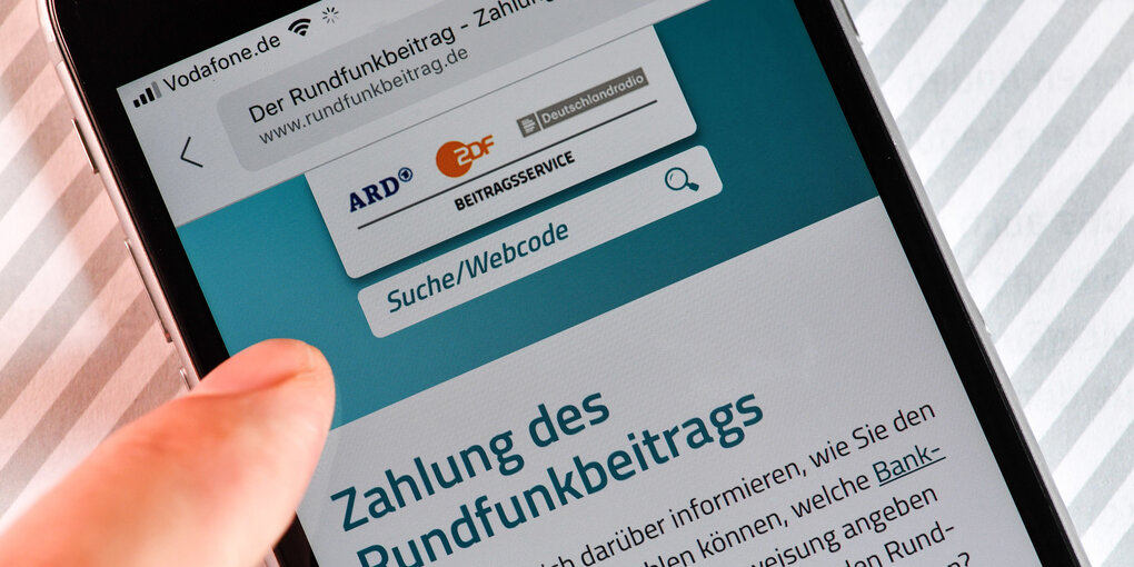 Ein Smartphone zeigt die Internetseite für die Zahlung des Rundfunkbeitrags