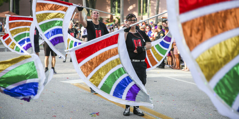 bei der Pride Parade in Sankt Petersburg schwenken Menschen Fahnen in Regenbogen-Farben.