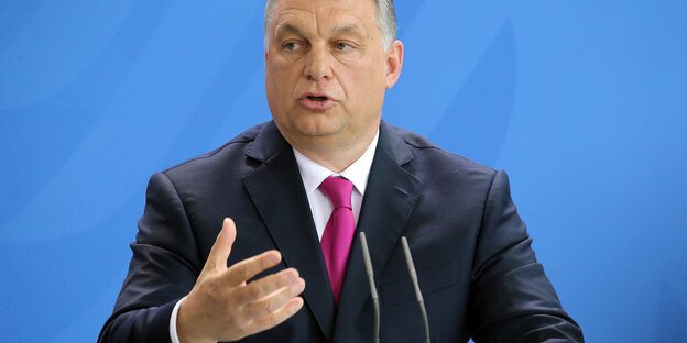 Ungarns Regierungschef Victor Orban redet an einem Pult. Er trägt einen dunklen Anzug.