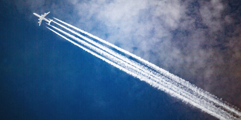 Ein Flugzeug zieht Kondensstreifen hinter sich