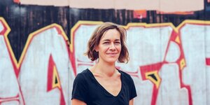 Die sächsische inken-Abgeordnete Juliane Nagel steht vor einer Wand mit Graffiti