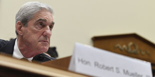 Robert Mueller an einem Tisch hinter seinem Namensschild