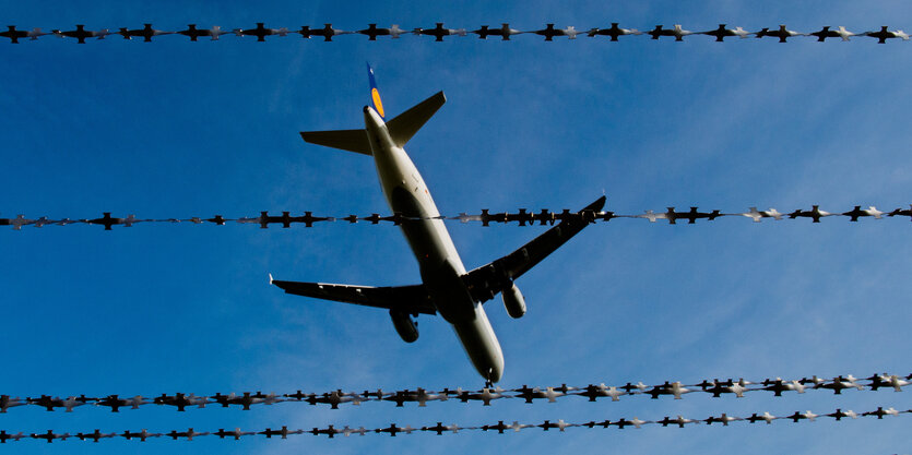 Ein Flugzeug fliegt am Flughafen in Hannover hinter Stacheldraht.