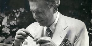 Aldous Huxley hält einen Stift in der Hand