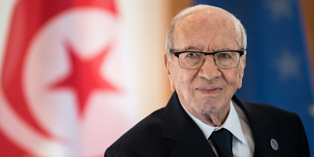 Beji Caid Essebsi steht vor der tunesischen und der EU-Flagge.