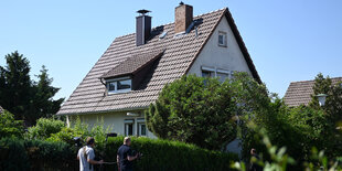 Ein Einfamilienhaus hinter einer Hecke