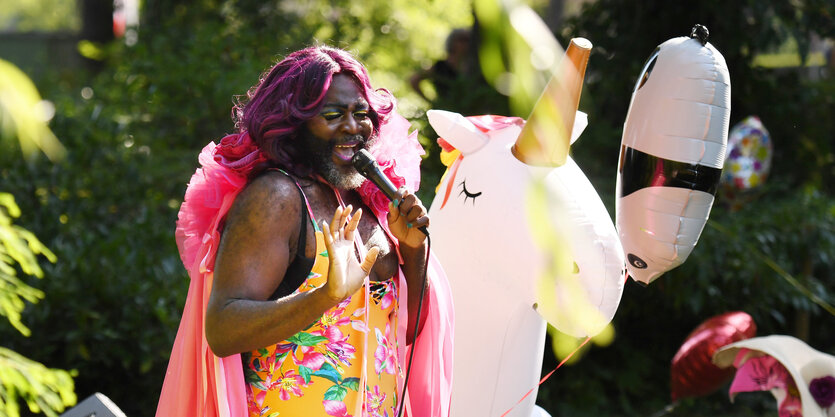 Le Gateau Chocolat singt neben einer aufgeblasene Einhornfigur