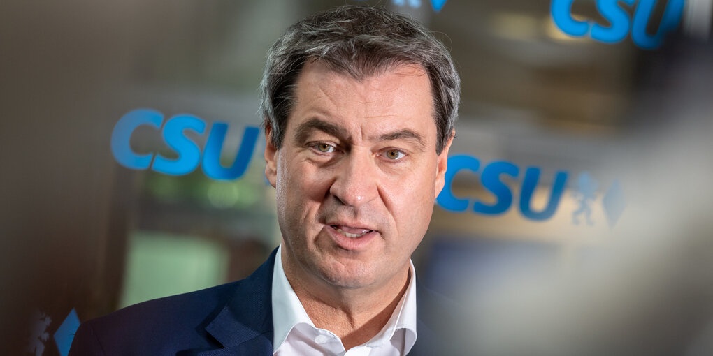 Markus Söder vor einer Glasscheibe mit der Aufschrift CSU