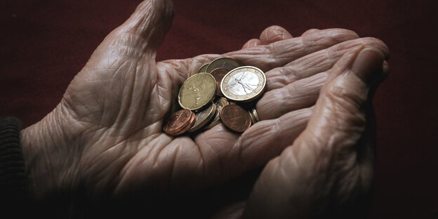 die Hände eines alten Menschen. Darin wenige Euromünzen.