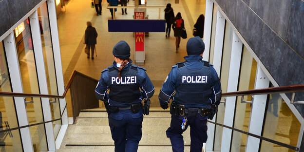 Zwei Polizeibeamte gehen eine Treppe hinunter