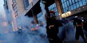 Ein Demonstrant wirft einen Tränengas Kanister