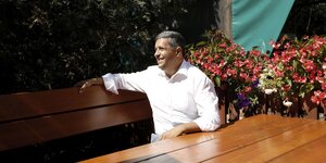 Raed Saleh sitzt entspannt auf einer Bank in einem Biergarten in Kladow