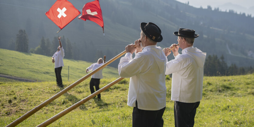 Zwei Fahnenschwinger und zwei Alphornbläser sind bei dem Festgottesdienst beim traditionellen Schwing- und Älplerfest