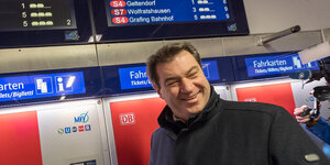 Markus Söder steht vor einem Ticket-Automat der Deutschen Bahn