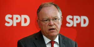 Mann mit Brille vor SPD-Logo. Es ist Stephan Weil