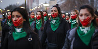 Frauen protestieren mit rot gemalten Händen auf dem Mund für eine Liberalisierung der Abtreibung