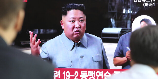 Man sieht einen diskutierenden Kim Jong Un, der im südkoreanischen Fernsehen zu sehen ist.