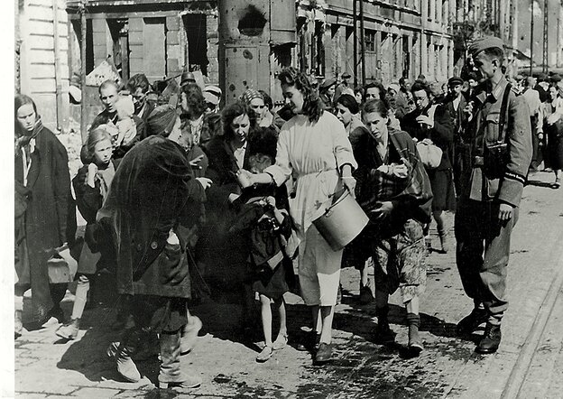 Eine Frau mit Topf verteilt Lebensmittel unter den Augen eines SS-Offiziers Eine Frau mit Topf verteilt Lebensmittel unter den Augen eines SS-Offiziers
