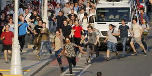 Eine Menge von jungen Leuten rennt die Straße entlang
