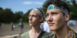 Zwei junge Klimaaktivisten blicken skeptisch in die Weite. Sie tragen Kopfbinden mit der Aufschrift: Tempo Machen beim Kohleausstieg