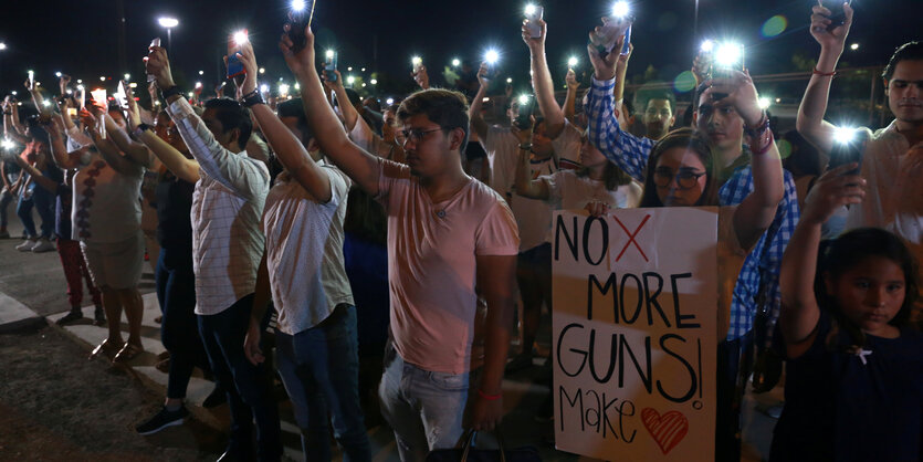 Trauernde stehen am Grenzzaun zwischen Mexiko und El Paso nach dem Massaker