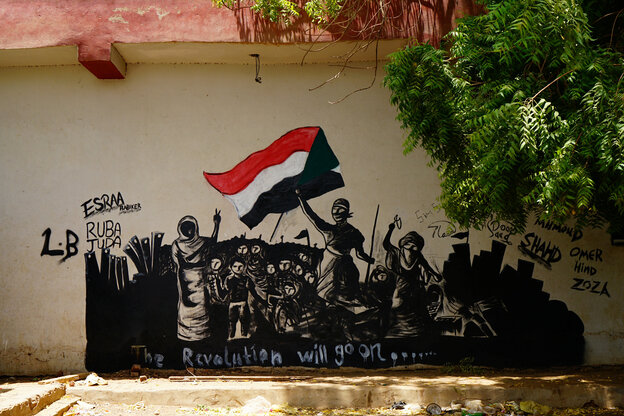 Ein Bild an der Mauer erinnert an das berühmte Gemälde der französischen Revolution, aber die sudanesische Flagge und Sudanesen sind stattdessen zu sehen. Darunter steht: "The Revolution will go on"