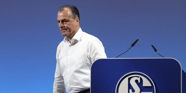 Clemens Tönnies im weißen Hemd, neben ihm ein Rednerpult mit dem Schalke-Logo