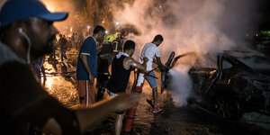 05.08.2019, Ägypten, Kairo: Menschen löschen ein Feuer nach einer Explosion in der Nähe des Krebsforschungsinstituts.