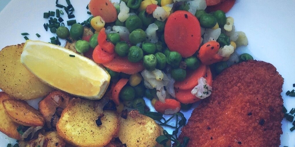 Ein Teller mit Bratkartoffeln, Mischgemüse und Fisch aus der Pfanne