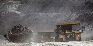 Mit Kohle beladene LKWs in einem Tagebau