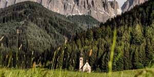 Eine Kirche vor düsteren Tiroler Bergen