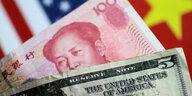 US-Dollar-Noten, dahinter ein Yuan Geldschein mit dem Gesicht von Mao