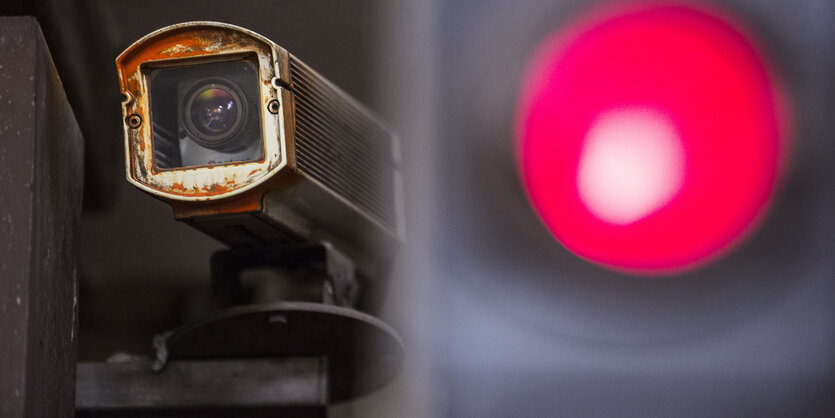 Eine Kamera filmt das Geschehen. Rechts von ihr leuchtet eine rote Ampel