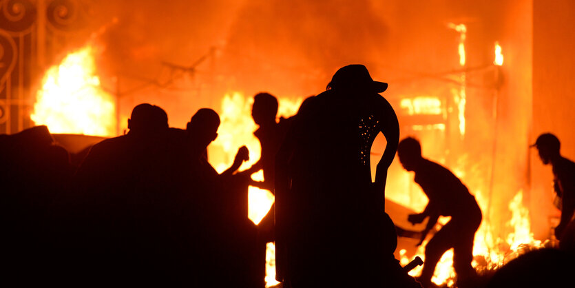 Silhouetten vor Feuerschein