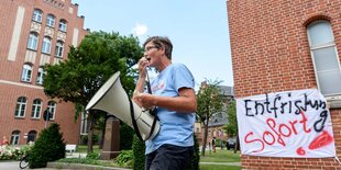 Protest gegen Outsourcing an der Charité in Berlin: Eine Frau hält ein Megaphon