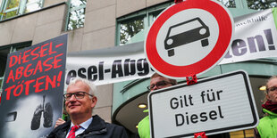 Der Geschäftsführer der Deutschen Umwelthilfe Jürgen Resch steht neben einem Durchfahrt-Verboten-Schild, unter dem "Gilt für Diesel" steht