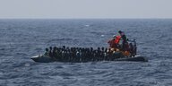 Ein Schlauchboot voller Menschen im Meer