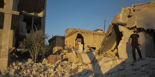 Ein Mann steht nach einem Luftangriff auf Gebäudetrümmern in Chan Schaichun, Syrien.
