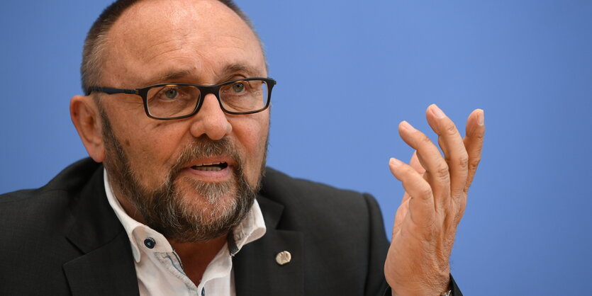 Frank Magnitz von der AfD spricht bei einer Pressekonferenz. Er hebt die Hand