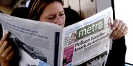 Eine Frau liest in einer Bahn Metro